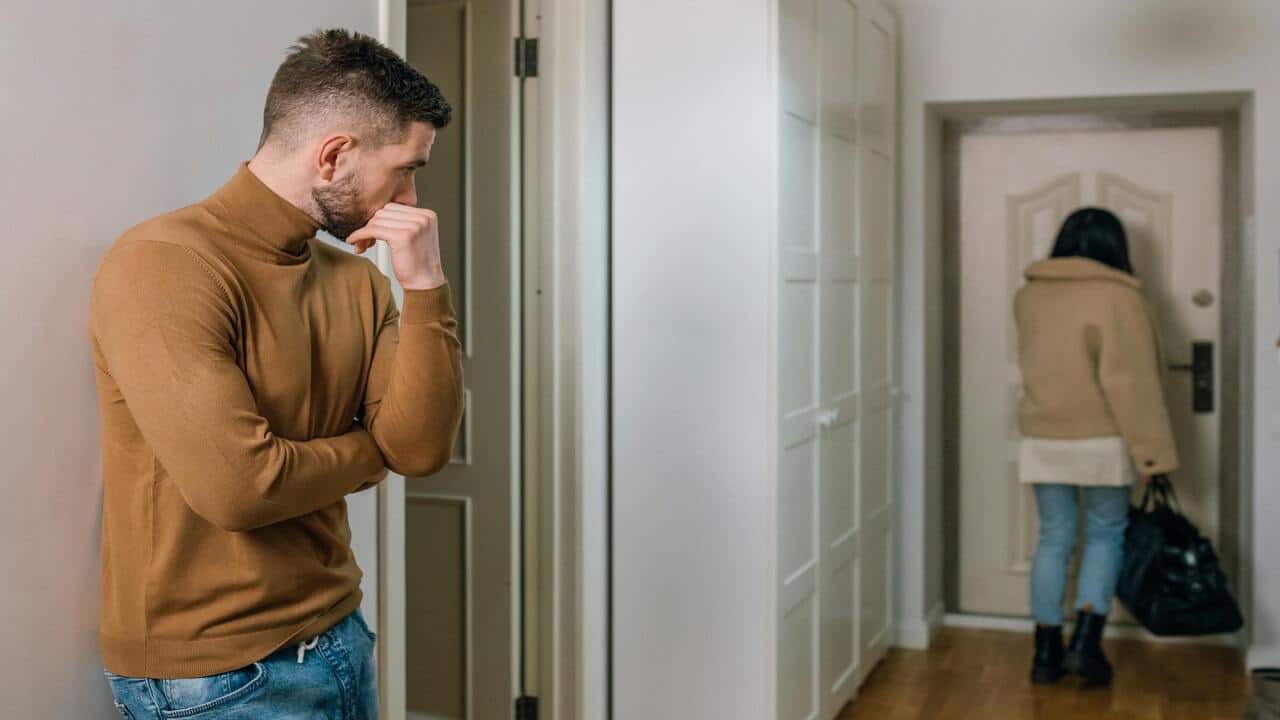 A man looking at a woman walking away