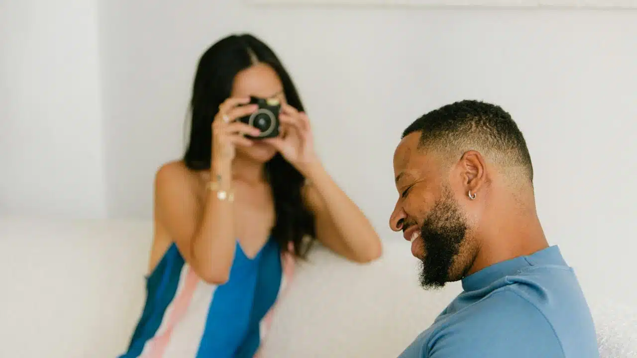 A woman taking a picture of a man with a  camera.